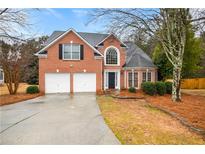 Brick house with two-car garage and landscaped yard at 780 Treadstone Ct, Suwanee, GA 30024