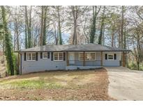 Newly renovated ranch home with gray brick exterior, modern porch, and long driveway at 1707 Boulderview Se Dr, Atlanta, GA 30316