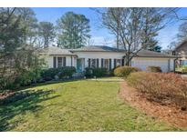 Ranch style home with landscaped lawn and attached garage at 450 Knoll Woods Dr, Roswell, GA 30075