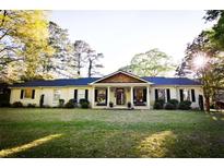 Brick ranch home with covered porch, mature landscaping, and a spacious yard at 5190 Crestview Dr Se, Covington, GA 30014