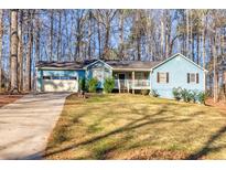 Ranch style home with attached garage, and a spacious front yard at 215 Silver Creek Ln, Stockbridge, GA 30281