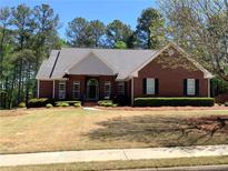 Brick home with gray roof, landscaping, and a large front yard at 517 Mary Margaret Walk, Loganville, GA 30052