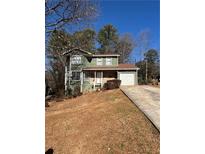 Green two-story house with a red roof and a stone facade at 5250 Mountain Village Ct, Stone Mountain, GA 30083