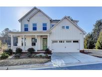 Two-story farmhouse with white siding, green door, and attached two-car garage at 4090 Glasnill Rd, Suwanee, GA 30024