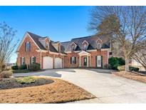 Brick house with a three-car garage and manicured lawn at 4901 Planters Walk, Douglasville, GA 30135