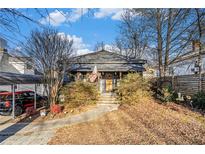 Charming home with a covered parking area and a quaint front porch, surrounded by mature landscaping at 8338 Dallas Hwy, Douglasville, GA 30134