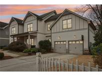 Two-story house with gray siding, two-car garage, and white picket fence at 370 Park Ne Pl, Atlanta, GA 30317