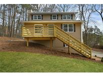 Charming home with a new deck and stairs leading to a grassy front yard at 1630 Acworth Due West Nw Rd, Kennesaw, GA 30152