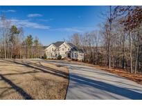 Two-story house with a long driveway, situated on a large lot with mature trees at 45 Kinloch Ct, Covington, GA 30014