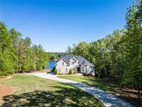 Stunning two-story home with a long driveway, lush landscaping, and lake view at 45 Kinloch Ct, Covington, GA 30014