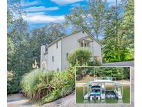 Charming two-story home with a landscaped front yard and a private boat dock on the lake at 8535 Lynn Dr, Cumming, GA 30041