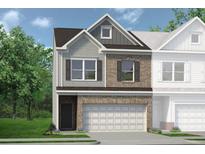 Two-story townhome with gray and brick exterior, two-car garage, and landscaping at 24 Jacobs Farm Ln # 12, Lawrenceville, GA 30045