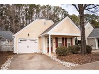 Charming light yellow house with white garage door and red shutters at 5055 Kathryn Glen Dr, Acworth, GA 30101