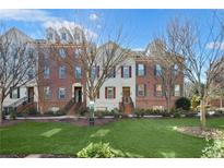Charming townhome showcasing a brick facade, shutters, and well-manicured lawn at 879 Perennial Dr, Sandy Springs, GA 30328
