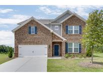 Two story brick home with a three car garage and landscaped lawn at 1246 Allspice Way, Lawrenceville, GA 30045