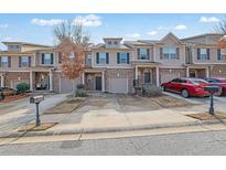 Attractive townhomes featuring attached garages, well-maintained landscaping, and welcoming front entrances at 2725 Morgan Glen Rd, Buford, GA 30519