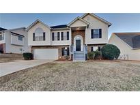 Two-story house with brick and vinyl siding, attached garage, and landscaping at 5693 Colonnade Dr, Rex, GA 30273