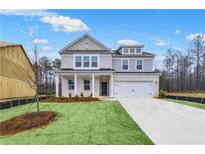 Charming two-story home with a well manicured lawn, two-car garage, and brick and siding accents at 6076 Marigold Way, Atlanta, GA 30349