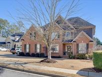 Charming two-story brick home with a well-manicured lawn and mature tree at 3641 Carriage Glen Way, Dacula, GA 30019