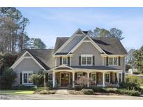 Two-story house with gray siding, a wraparound porch, and landscaping at 380 S Woodland Sw Dr, Marietta, GA 30064