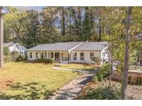 Charming white brick home with manicured lawn, front porch and driveway at 3643 N Stratford Ne Rd, Atlanta, GA 30342