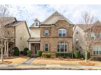 Charming two-story brick home featuring manicured landscaping, complemented by light colored shutters and trim at 4332 Ainsley Mill Ln, Duluth, GA 30097