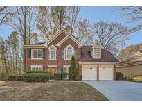 Brick two-story house with attached two-car garage and landscaped yard at 7075 Waters Edge Dr, Stone Mountain, GA 30087