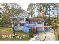 Charming two-story home featuring a spacious driveway, complemented by a well-maintained yard and a treed background at 3566 Carry Ct, Snellville, GA 30039