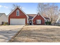 Charming brick-accented home with a well-manicured lawn and attached two-car garage at 1020 Sunhill Dr, Lawrenceville, GA 30043