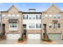 Three-story townhouses with brick and siding exteriors, two-car garages, and landscaping at 2641 Blackburn Ct, Smyrna, GA 30080