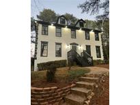 Two story home with white siding, black trim, and stone steps leading to the entrance at 911 David Dr, Lawrenceville, GA 30046