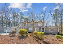 Two-story house with a three-car garage and manicured landscaping at 213 Pine Crest Dr, Cumming, GA 30040