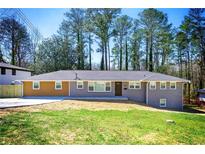 Charming single-story home featuring manicured lawn, brown and gray exterior, and a welcoming front entrance at 681 Fielding Sw Ln, Atlanta, GA 30311