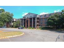 Spacious apartment building featuring a large parking area and multiple balconies at 3091 Colonial Way # C1, Atlanta, GA 30341