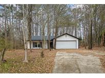 Ranch home with attached garage, nestled in a wooded lot at 7037 Shangrila Trl, Riverdale, GA 30296