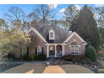 Charming brick home featuring a well-manicured lawn and inviting rocking chair front porch at 3377 Fielders Point, Dacula, GA 30019