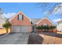 Brick house with two-car garage and landscaped yard at 3709 Northsails Ct, Conyers, GA 30013