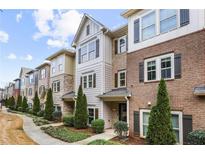 Charming townhome with a brick and siding exterior, showcasing a well-maintained front yard and inviting entrance at 3058 Turman Cir, Decatur, GA 30033