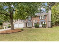 Two-story brick home with attached two-car garage and landscaped yard at 280 Sea Holly Cir, Roswell, GA 30076