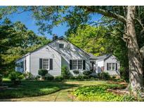 Charming white house with black shutters, landscaped yard, and mature trees at 5154 Central Dr, Stone Mountain, GA 30083