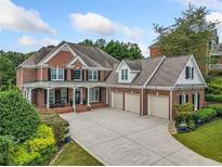 Brick house with three-car garage and landscaped yard at 131 Gold Springs Ct, Canton, GA 30114
