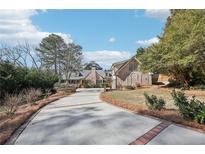 Charming brick home featuring a long driveway and beautifully landscaped front yard at 3930 Peachtree Dunwoody Ne Rd, Atlanta, GA 30342