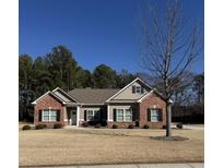 Brick ranch home with a large front yard and mature trees at 922 Golden Meadows Ln, Loganville, GA 30052