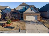 Charming single-Gathering home with a brick and gray facade, a well-manicured lawn, and an attached two-car garage at 2733 Madison Mae Ln, Grayson, GA 30017