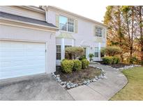 Two-story house with a white brick facade, attached garage, and well-manicured landscaping at 335 Wilma Sw Ct, Atlanta, GA 30331