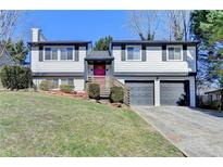 Charming two-story home featuring a well-manicured lawn and attached two-car garage at 1230 Worthington Hills Dr, Roswell, GA 30076