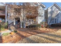 Charming condo exterior with stone accents, a front porch, and a well-maintained landscaped yard at 305 Madison Se Ct # 305, Smyrna, GA 30080