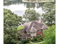 Aerial view of house on lake with large lot and mature trees at 2697 Bethel Ne Rd, Conyers, GA 30012