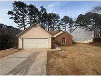 Ranch home with brick and vinyl siding, attached garage, and a spacious yard at 754 Shore Dr, Lithonia, GA 30058