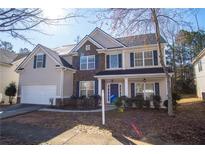 Charming two-story home featuring stone accents, a manicured lawn, and a two-car garage at 7972 Applemist Dr, Fairburn, GA 30213